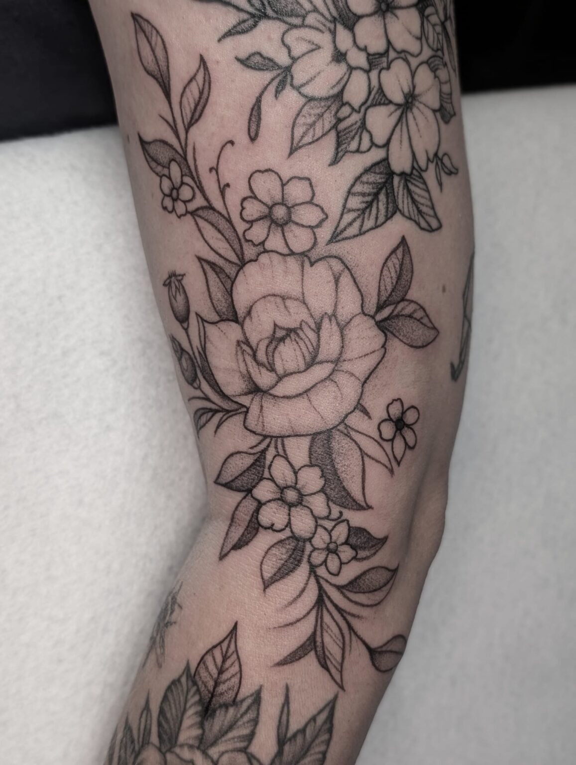Florales Tattoo mit Rosen und Blüten – fein schattiert. Blumen-Tattoo aus Menden, Unna, Wickede, Iserlohn, Werl.