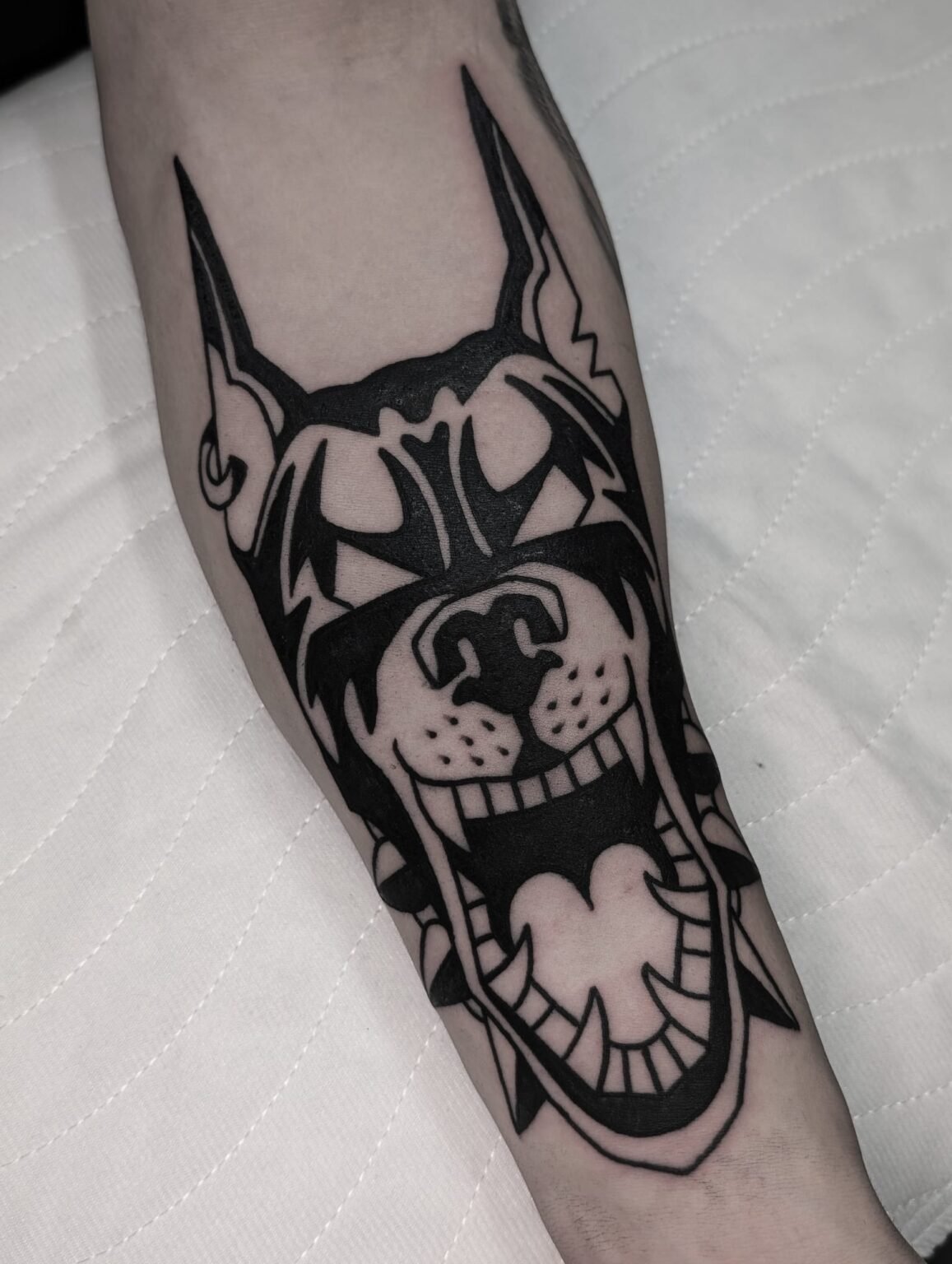 Boldes Tattoo eines wütenden Dobermanns im Neo-Tribal-Stil – starke Linien, intensive Wirkung. Tätowierung aus Menden, Unna, Wickede, Iserlohn, Werl.