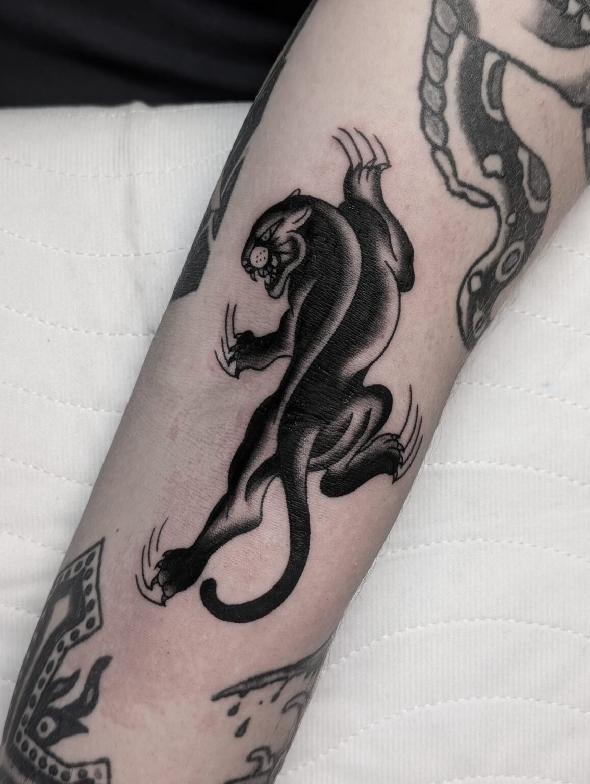 Traditionelles Black Panther Tattoo im Old School Stil – kraftvoll und dynamisch. Tätowierung aus Menden, Unna, Wickede, Iserlohn, Werl.